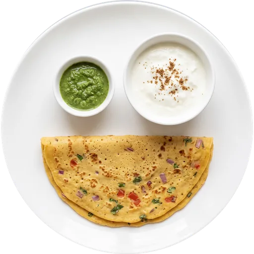 Besan chilla with curd and green chutney on a white plate